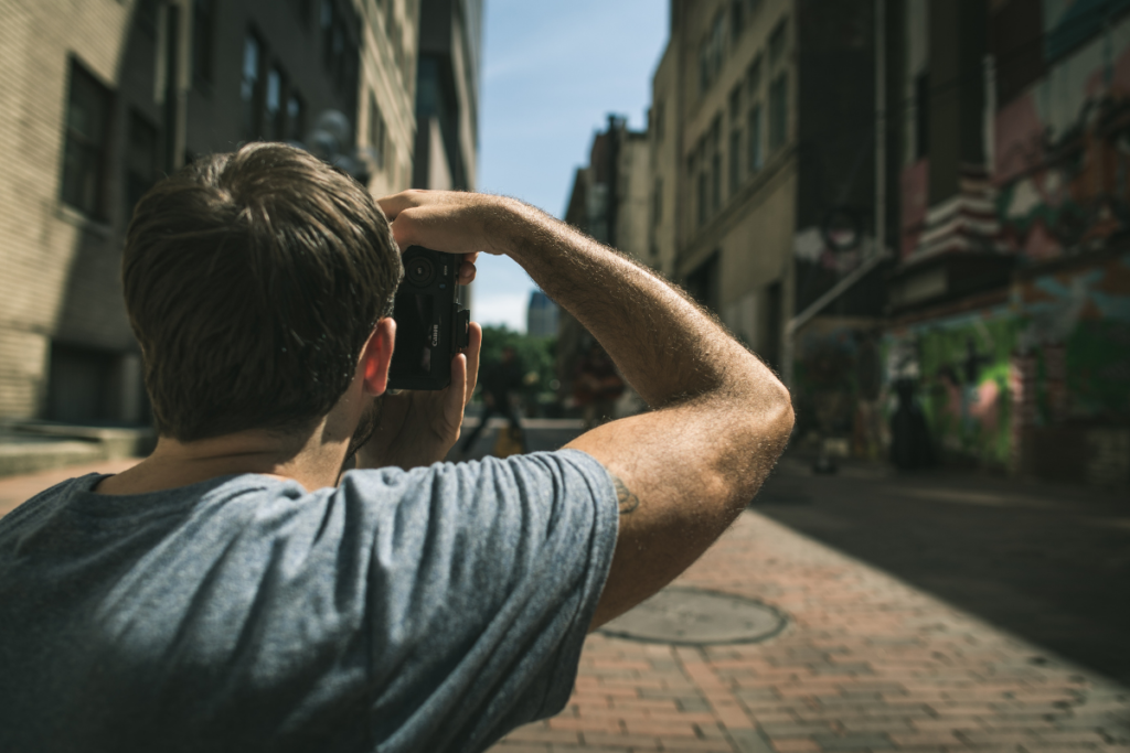 A picture of a person taking a photo of buildings in an urban area