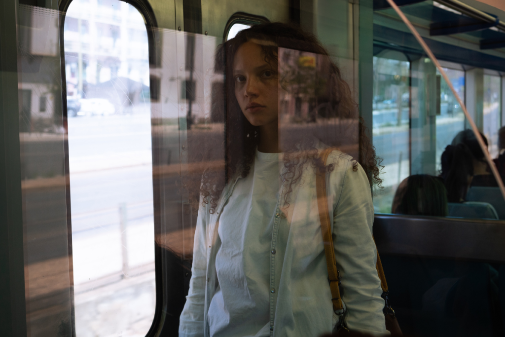 A picture of a woman through a window on a train