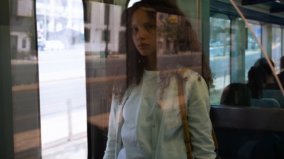 A picture of a woman through a window on a train