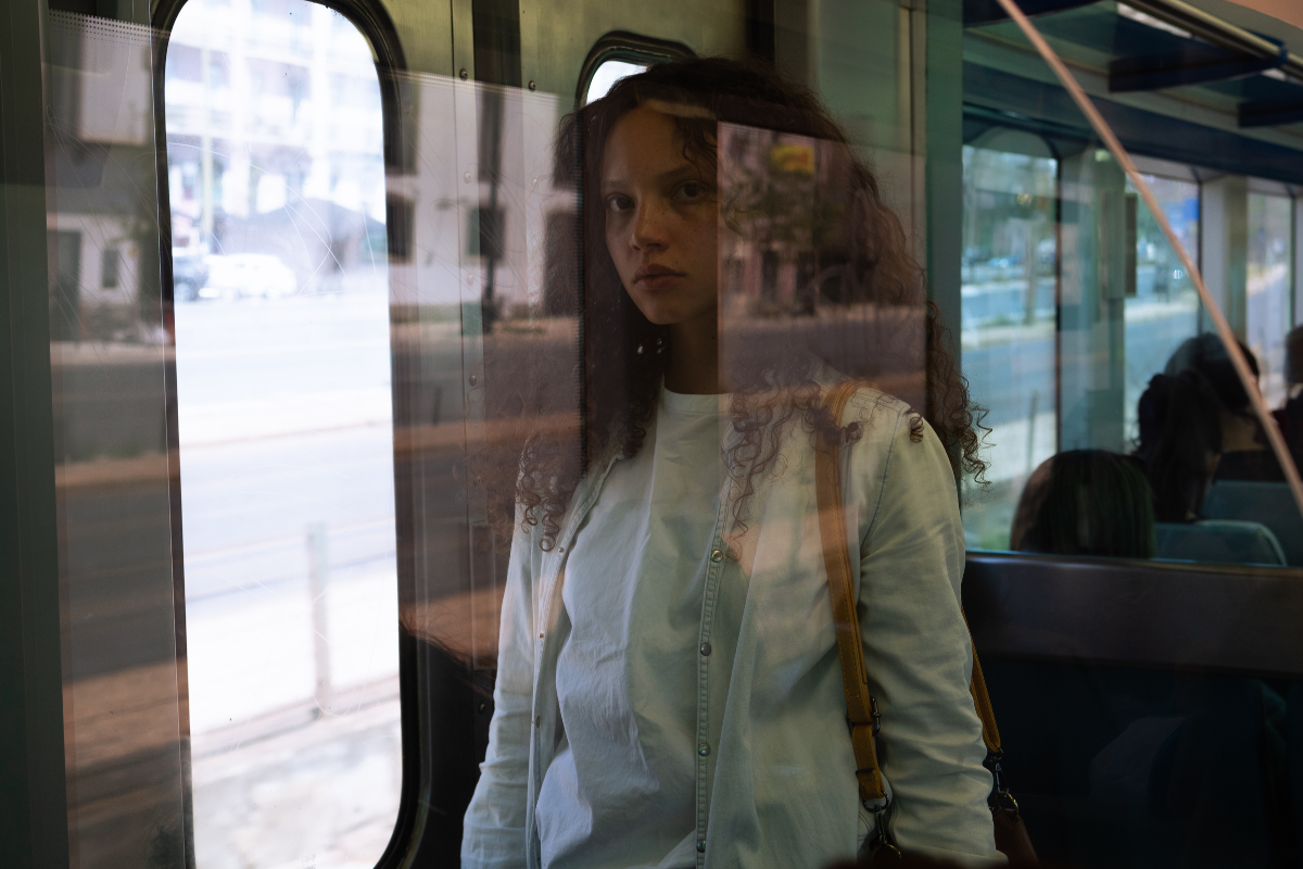 A picture of a woman through a window on a train