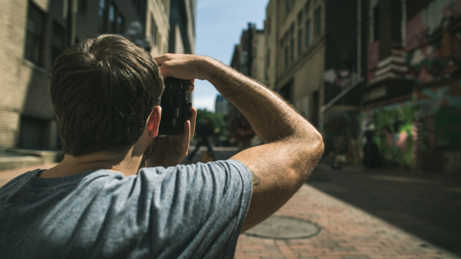 A picture of a person taking a photo of buildings in an urban area